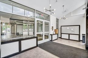 Maple Shade apartment for rent - A modern office space with a reception desk and a calendar on the wall.