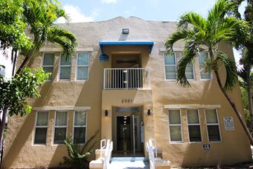 Miami apartment for rent - A building with a blue roof and a balcony with white railings.