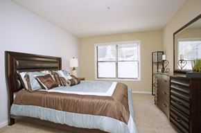 Stone Mountain apartment for rent - A bedroom with a brown headboard and a blue bedspread.