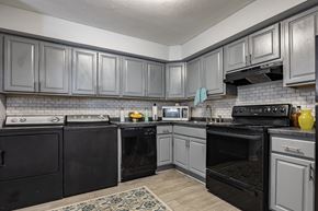 Fairburn apartment for rent - A kitchen with black appliances and grey cabinets.