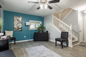 Fairburn apartment for rent - A living room with a staircase and a ceiling fan.