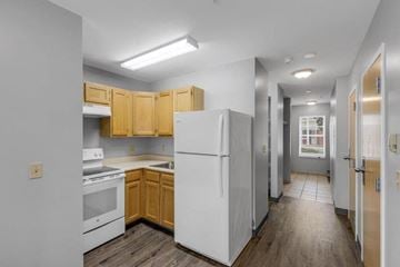 Brunswick apartment for rent - a kitchen with white appliances and wooden cabinets