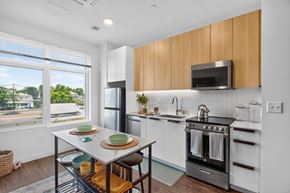 Allston apartment for rent - A kitchen with a table set for two with plates and glasses on it at The Indie in Allston.