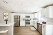 Shirley apartment for rent - A renovated kitchen with white cabinets and appliances at Birchwood Hills Townhomes in Shirley, MA.
