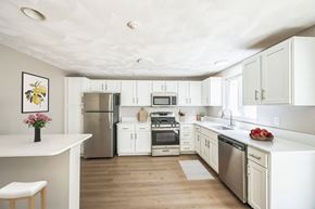 Shirley apartment for rent - A renovated kitchen with white cabinets and appliances at Birchwood Hills Townhomes in Shirley, MA.