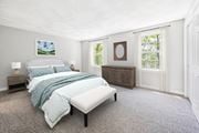 Shirley apartment for rent - A bedroom with a large bed, a window and carpet flooring at Birchwood Townhomes in Shirley, MA.