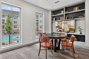 Danbury apartment for rent - A dining room with a table and chairs and a view of a pool and buildings outside.