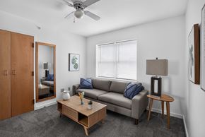 Brunswick apartment for rent - A living room with a grey couch, a wooden coffee table, and a ceiling fan.