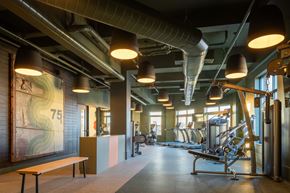 Manchester apartment for rent - A gym with a bench, weights, and exercise equipment.