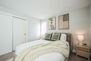 Chelmsford apartment for rent - A bedroom with a bed covered in a white blanket and pillows.
