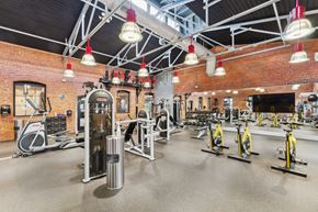 Glastonbury apartment for rent - a gym with weights and cardio equipment and a brick wall at The Tannery, Glastonbury