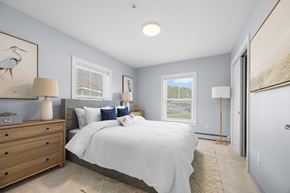 Brunswick apartment for rent - A bedroom with a large bed and a painting of a bird on the wall.
