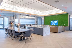 Kittery apartment for rent - A conference room with a long table and chairs, a reception desk, and a green wall with a TV at Seacoast Residences Apartments, Oakland, ME