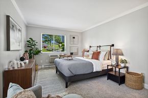 Danbury apartment for rent - A bedroom with a large bed and a window overlooking a backyard.