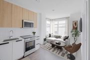 Allston apartment for rent - A modern kitchen with white cabinets and a black countertop.