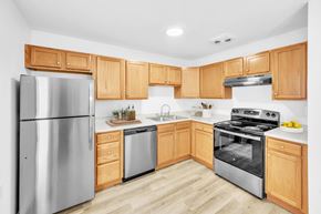 Hooksett apartment for rent - A modern kitchen with wooden cabinets and stainless steel appliances at Windsor Terrace, Hooksett, NH