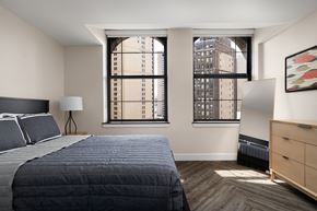 Detroit apartment for rent - a bedroom with a bed and two windows