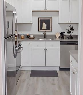 Taylor townhouse for rent - A modern kitchen with white cabinets and a stainless steel refrigerator.