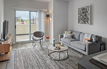 Detroit apartment for rent - A living room with a grey couch, a coffee table, and a television.