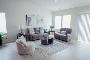 Holly apartment for rent - A living room with a grey sofa, a grey armchair, and a grey coffee table.