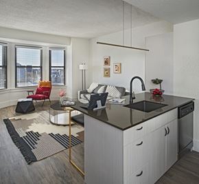 Detroit apartment for rent - A modern kitchen with a black countertop and white cabinets.