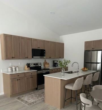 Holly apartment for rent - A kitchen with brown cabinets and a white countertop.