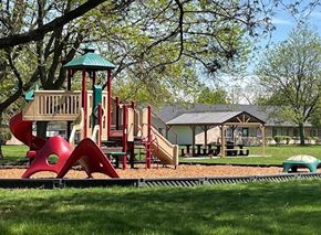 Taylor townhouse for rent - A playground with a red slide and a green roofed structure.