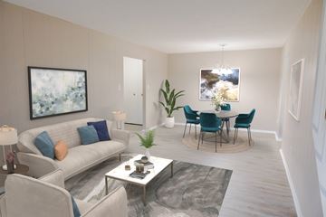 Taylor townhouse for rent - A living room with a grey couch, a coffee table, and a dining table set up.