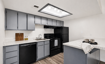 Phoenix apartment for rent - A modern kitchen with black appliances and grey cabinets.