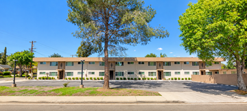 Escondido apartment for rent - A large building with a brown roof and a parking lot in front.