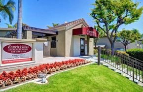 San Diego apartment for rent - a building with a sign in front of a lawn and a fence
