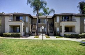 San Diego apartment for rent - an apartment building with stairs and palm trees