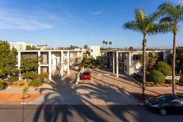 San Diego apartment for rent - A car is parked on the street in front of a building.