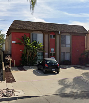 San Diego apartment for rent - A red building with a car parked in front.
