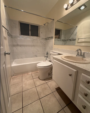 San Diego apartment for rent - A white toilet sits in a bathroom next to a sink and a bathtub.