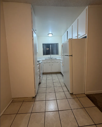 San Diego apartment for rent - A kitchen with white appliances and white cabinets.