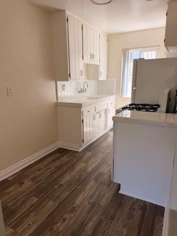 San Diego apartment for rent - A kitchen with white cabinets and a wooden floor.