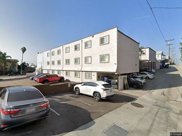 San Diego apartment for rent - A street view of a building with cars parked in front.