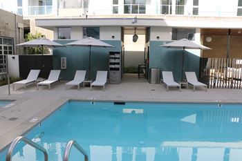 Pool pavilion with outdoor fire place a large tv and lounge area as well as restrooms with showers and lockers