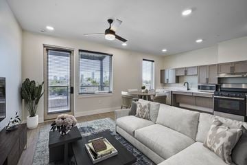 New Orleans apartment for rent - A modern living room with a large couch and a coffee table.