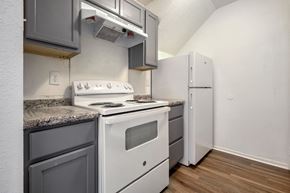 Gretna apartment for rent - A kitchen with a white stove and grey cabinets.