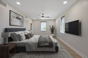 New Orleans apartment for rent - A bedroom with a large bed and a flat screen TV mounted on the wall.
