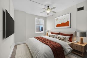 New Orleans apartment for rent - A bedroom with a large bed and a flat screen TV mounted on the wall.