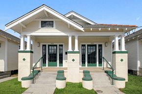 New Orleans triplex for rent - a white house with green doors and a porch