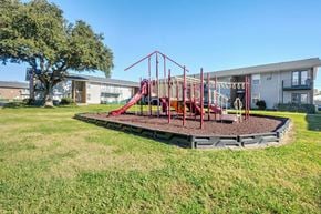 Harvey apartment for rent - A playground with a red swing set and a slide.