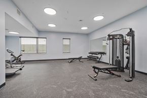New Orleans apartment for rent - A spacious gym with a variety of equipment including treadmills, elliptical machines, and weight machines.