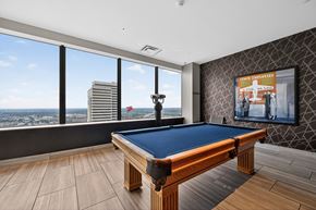 Dallas apartment for rent - A pool table in a room with a view of the city.