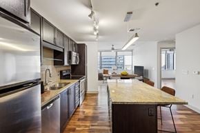 Dallas apartment for rent - A modern kitchen with dark wood cabinets and stainless steel appliances.