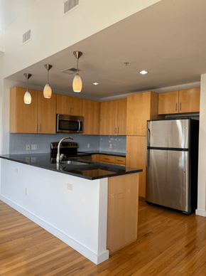 Richmond apartment for rent - A kitchen with wooden cabinets and a black counter top.