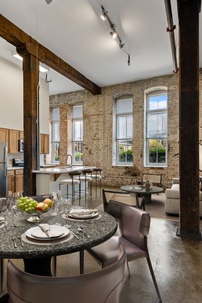 Shreveport apartment for rent - a dining room with a table and chairs and a kitchen with an exposed brick wall